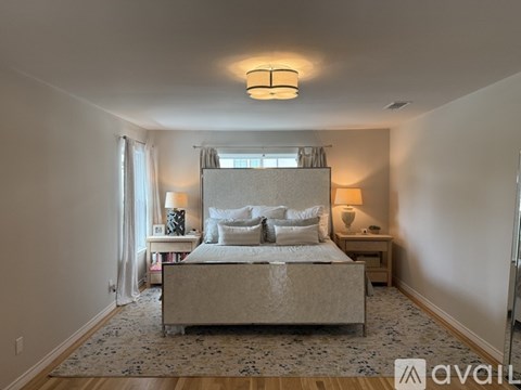 A bedroom with a large bed and a chandelier.