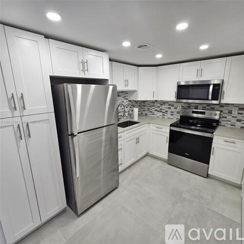 A kitchen with white cabinets and stainless steel appliances.