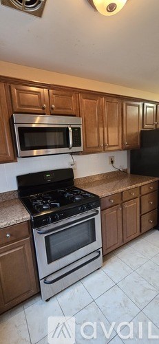 A kitchen with wooden cabinets and a stove top oven.
