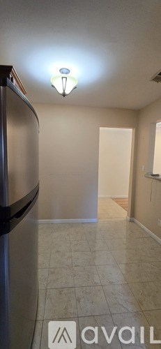 A kitchen with a fridge and a light on the ceiling.