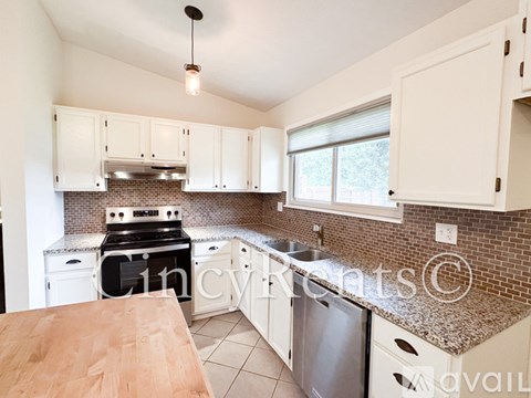 A kitchen with white cabinets and a wooden table.