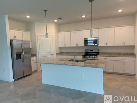 A kitchen with a granite countertop and stainless steel appliances.