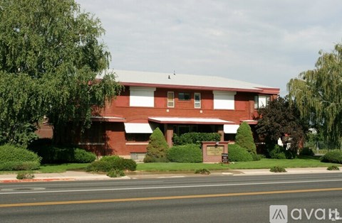 A red building with a white roof and a sign in front.
