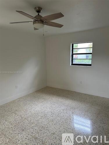 A room with a ceiling fan and a window.