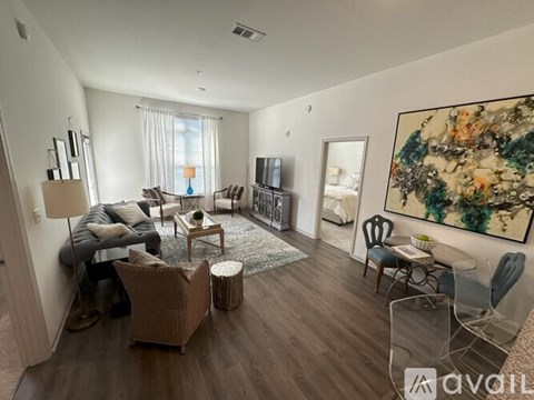 A living room with a large painting on the wall and a sofa set.