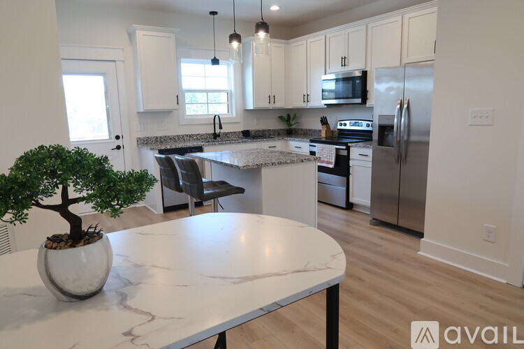 A white marble table with a plant on it in a kitchen.