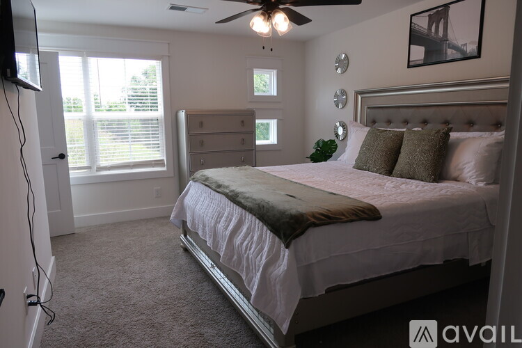 A bedroom with a large bed and a ceiling fan.