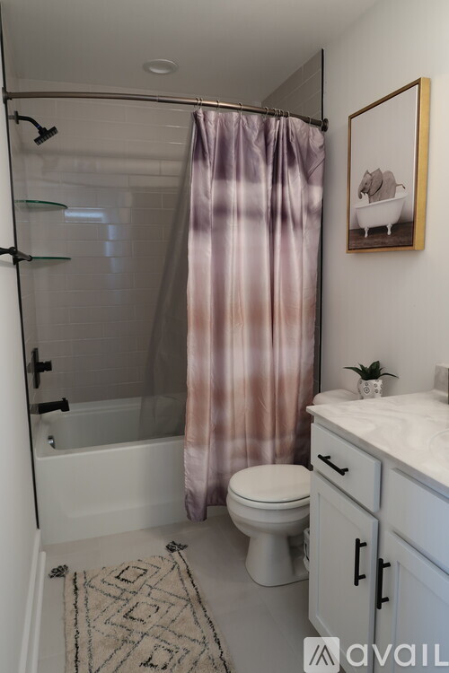 A bathroom with a toilet, sink, and shower.