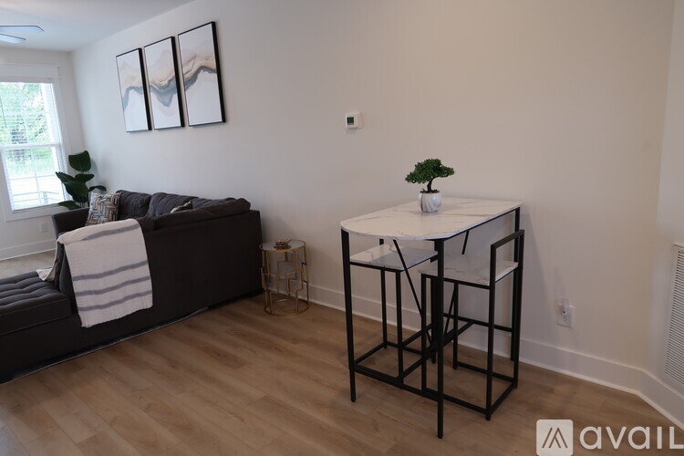 A living room with a black couch and a white table.