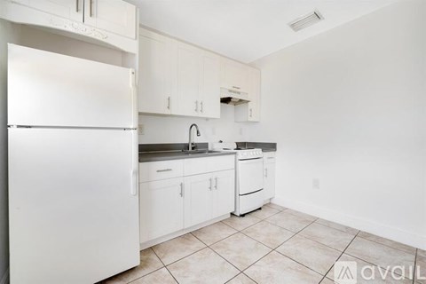 A kitchen with white appliances and cabinets.
