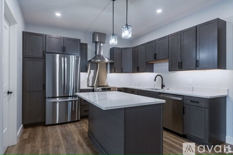 A modern kitchen with dark wood cabinets and stainless steel appliances.