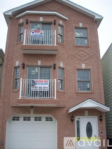 A red brick building with a white garage door and a sign that says "RODOLFO".
