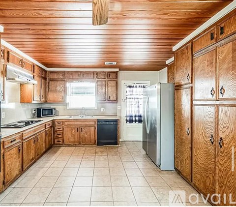 A kitchen with wooden cabinets and a tiled floor.