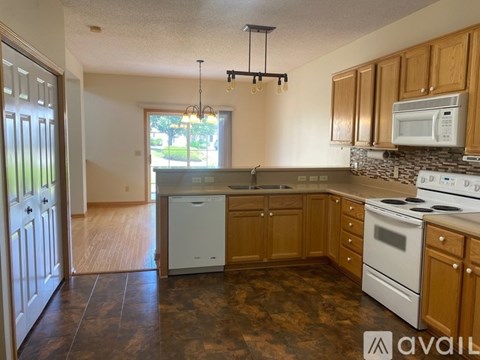 A kitchen with a white dishwasher and stove top oven.