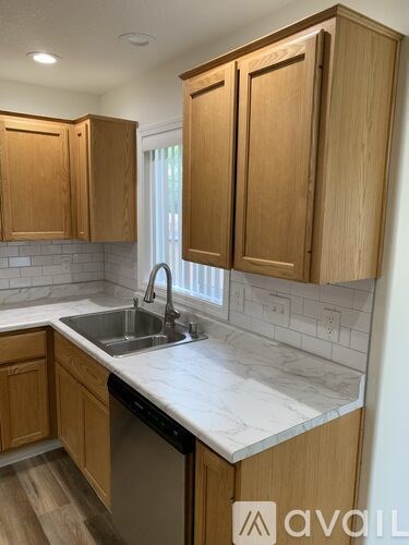 A kitchen with wooden cabinets and a marble countertop.