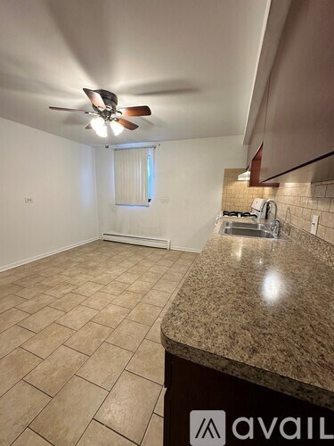 A kitchen with a counter and a fan on the ceiling.
