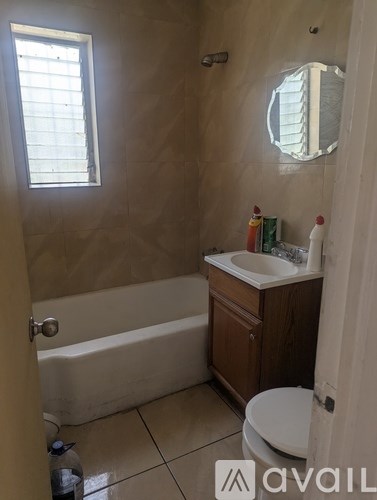 A bathroom with a tub, toilet, sink and mirror.