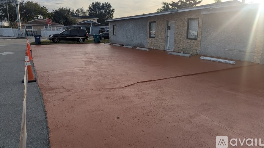 A parking lot with a car and a building in the background.