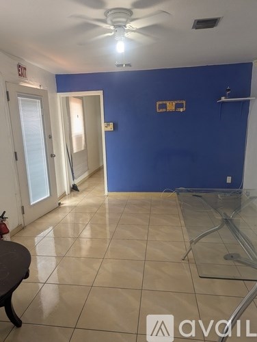 A room with a blue wall and a ceiling fan.