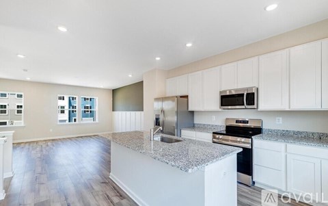 A kitchen with white cabinets and a granite countertop.