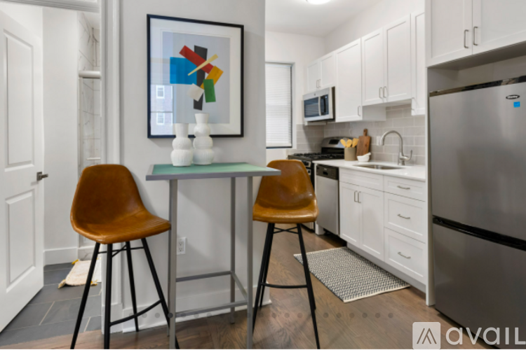 A kitchen with a table and chairs and a fridge.