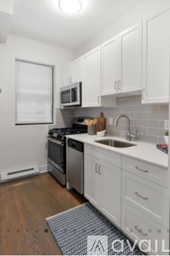 A kitchen with white cabinets and a stove top oven.