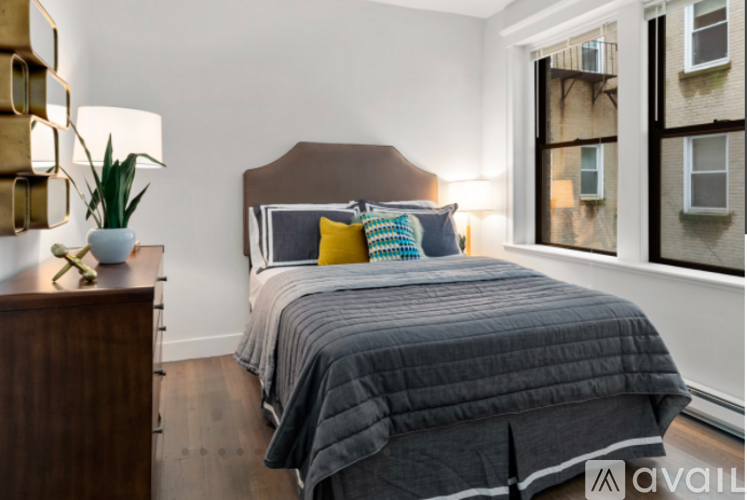 A bedroom with a large bed and a wooden dresser.