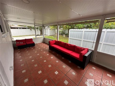 A living room with red couches and a tiled floor.
