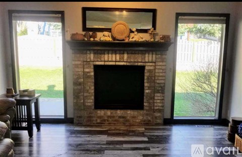 A living room with a fireplace and a television on the wall.