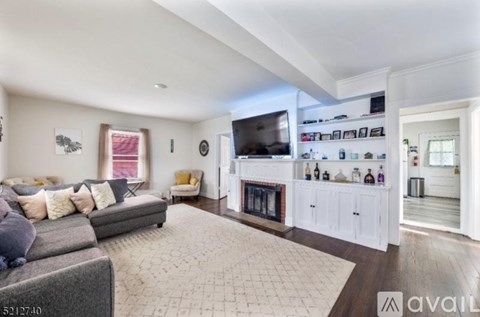 A living room with a grey couch and a fireplace.