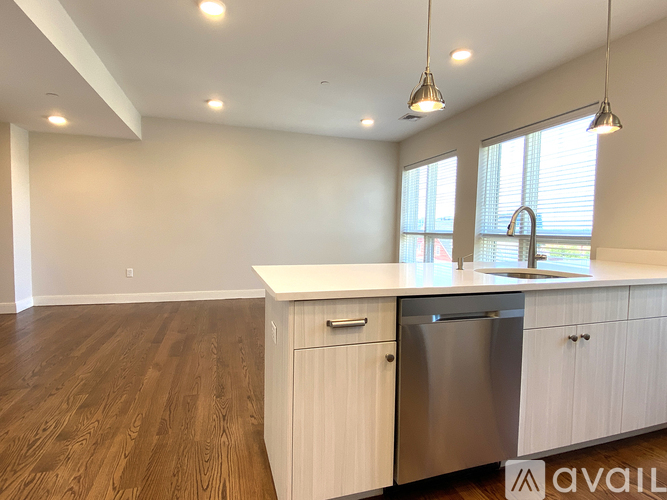 A kitchen with white cabinets and a stainless steel dishwasher.