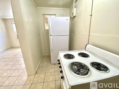 A white fridge and stove in a small kitchen.