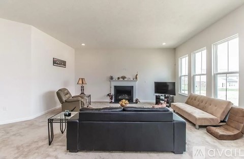 A living room with a black sofa and a fireplace.