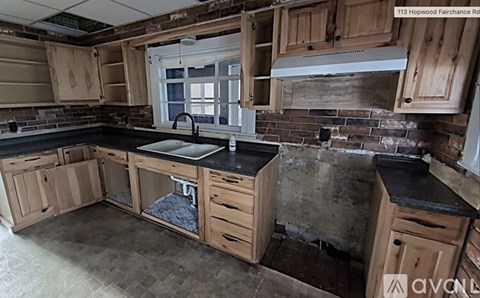 A kitchen with wooden cabinets and black countertops.