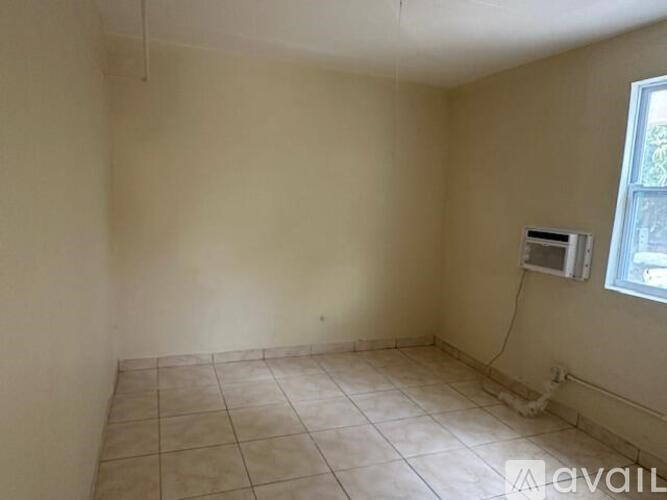 A room with a window and a tiled floor.