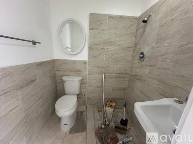 A bathroom with a toilet, sink, and mirror.