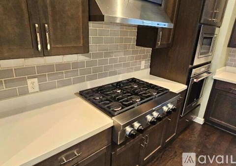 A kitchen with a stove top oven and a range hood.