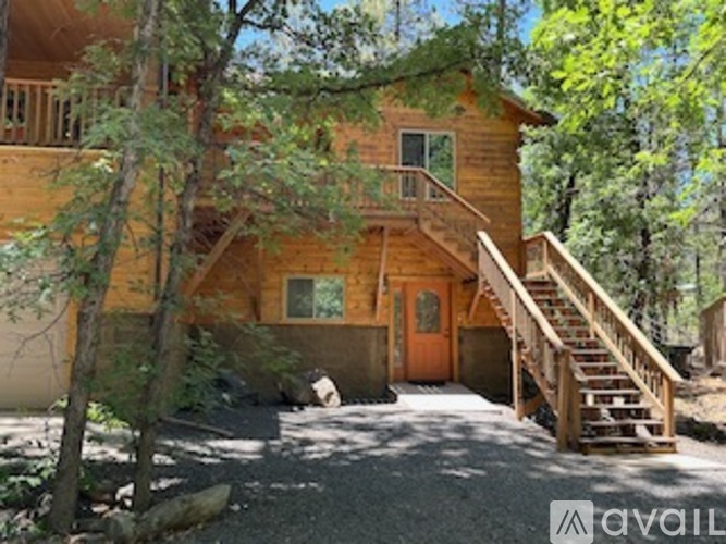 A wooden house with a staircase leading to the door.