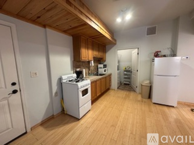 A kitchen with wooden floors and white appliances.