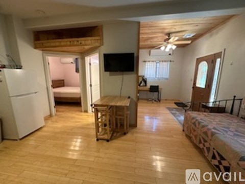 A living room with a television and a bed.