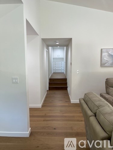 A living room with a couch and a staircase in the background.