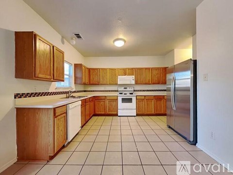 A kitchen with wooden cabinets and a white fridge.