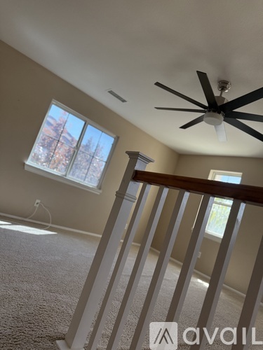 A room with a ceiling fan and a window.