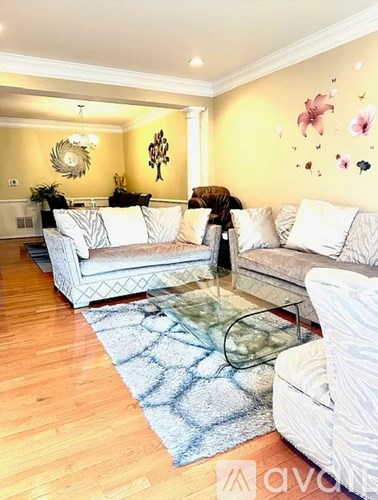 A living room with a white sofa and a glass coffee table.