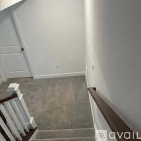 A staircase with a white railing and a brown handrail.