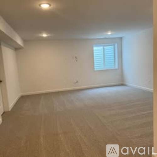A room with a window and wooden flooring.