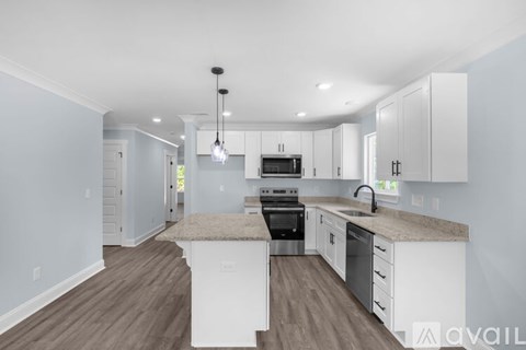 A kitchen with white cabinets and a center island.