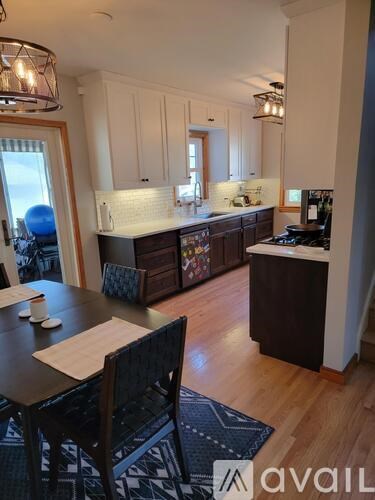 A kitchen with a table and chairs in front of it.