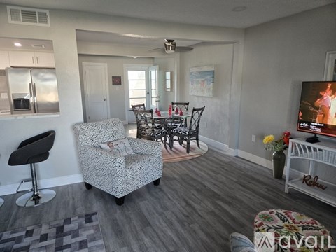 A living room with a grey patterned sofa and a black chair.