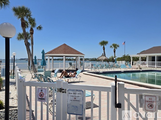 A pool area with a white fence and signs that say no swimming.